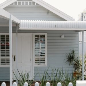white wooden house with green plants